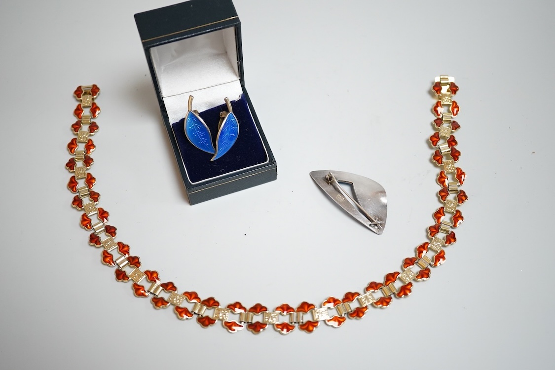 A pair of Norwegian gilt sterling and blue enamel ear clips by David Andersen, 31mm, together with one other Norwegian 925S and blue enamel free form brooch, 47mm and a gilt 925S and red enamel set necklace, 39.5cm.